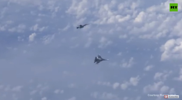▲▼ 西班牙F/A-18「大黃蜂」接近俄羅斯國防長紹伊古（Sergei Shoigu）搭乘的飛機後，被護衛的蘇-27驅逐。（圖／翻攝自Youtube／RT）