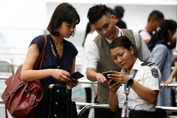 ▲在香港機場1號航站樓入口處安檢人員的登機牌和旅行證件。（圖／路透）