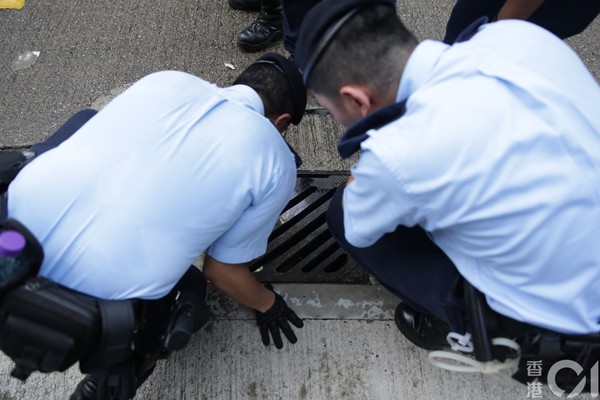 ▲警察仔細搜索，水溝蓋及垃圾桶皆不放過。（圖／香港01授權提供，請勿隨意翻攝，以免侵權）