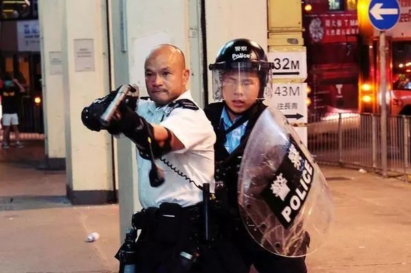 ▲「光頭警長」舉起手上的槍警告香港示威者。（圖／翻攝自新浪）