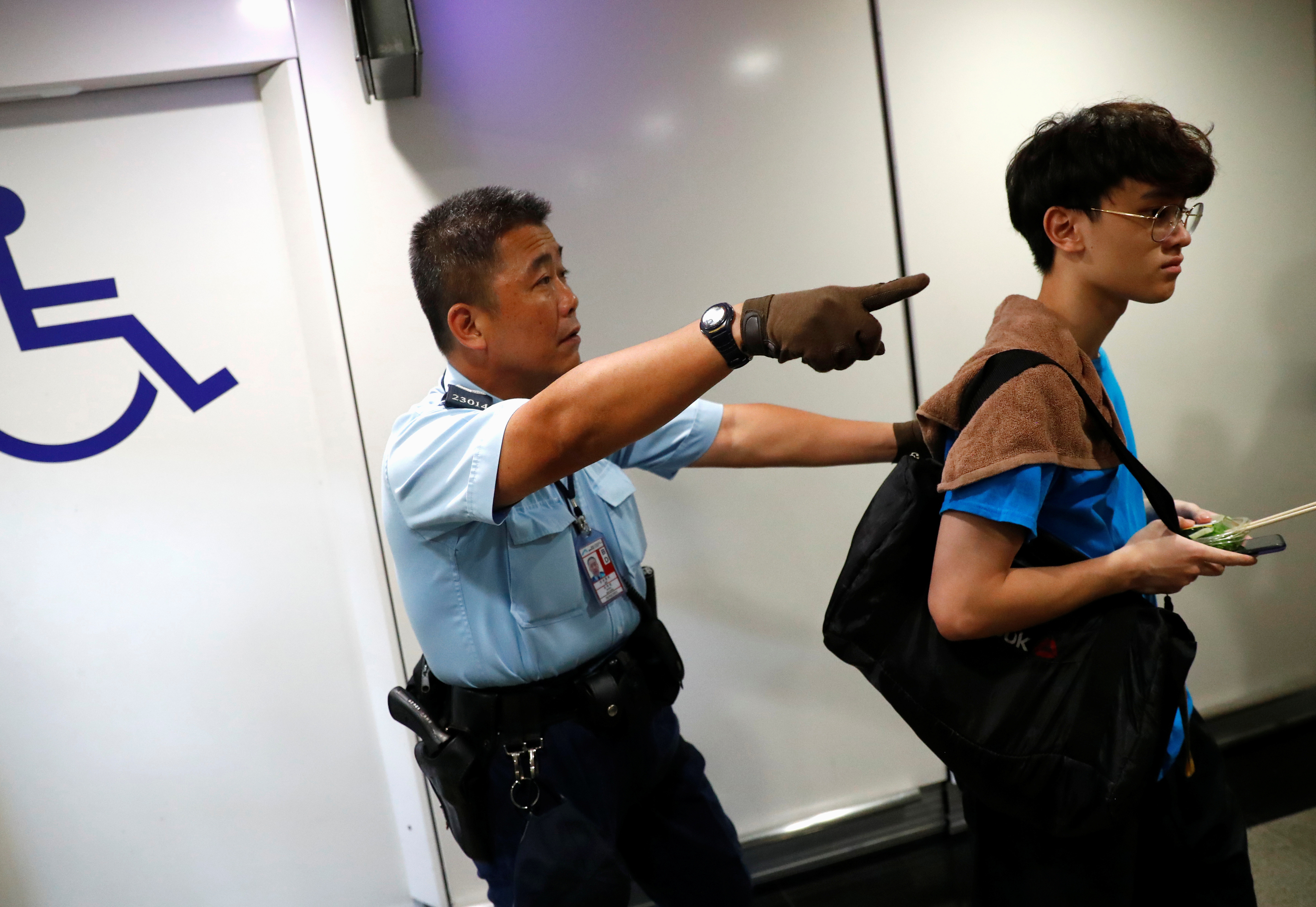 ▲警員驅散1名香港機場內的人。（圖／路透）
