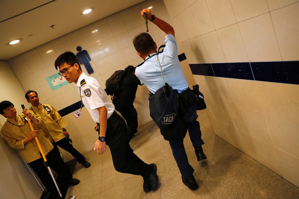 ▲警員在香港機場內追逐快閃民眾。（圖／路透）