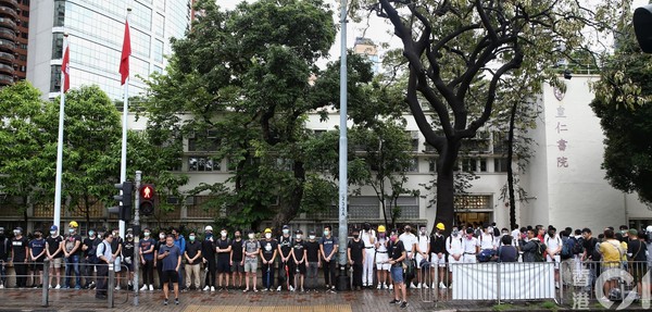 ▲香港皇仁書院有學生、舊生今早於校門外穿齊裝備，高呼口號、發傳單。（圖／香港01授權提供，請勿隨意翻攝，以免侵權，下同）