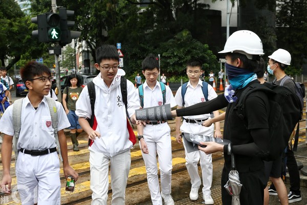 ▲香港皇仁書院有學生、舊生今早於校門外穿齊裝備，高呼口號、發傳單。（圖／香港01授權提供，請勿隨意翻攝，以免侵權，下同）