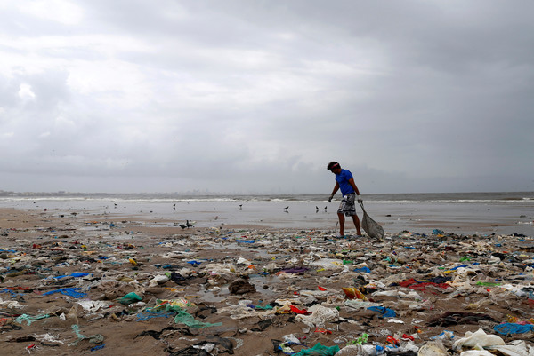 ▲▼ 一名志工在清理孟買海灘上的塑膠垃圾。（圖／路透）