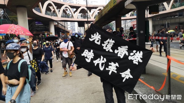 ▲香港929遊行現場，許多示威者參與，並拿著各國國旗揮舞。（圖／記者黃彥傑攝）