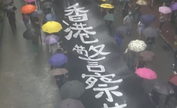 ▲▼民眾不畏風雨加入「反蒙面法」遊行。（圖／翻攝自香港電台視像新聞）