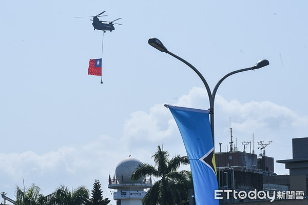 ▲108年國慶大典，運輸直升機吊掛國旗通過觀禮台。（圖／記者林敬旻攝）