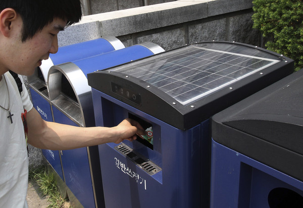 ▲▼ 2013年，南韓一名學生使用太陽能垃圾桶。（圖／達志影像／美聯社）