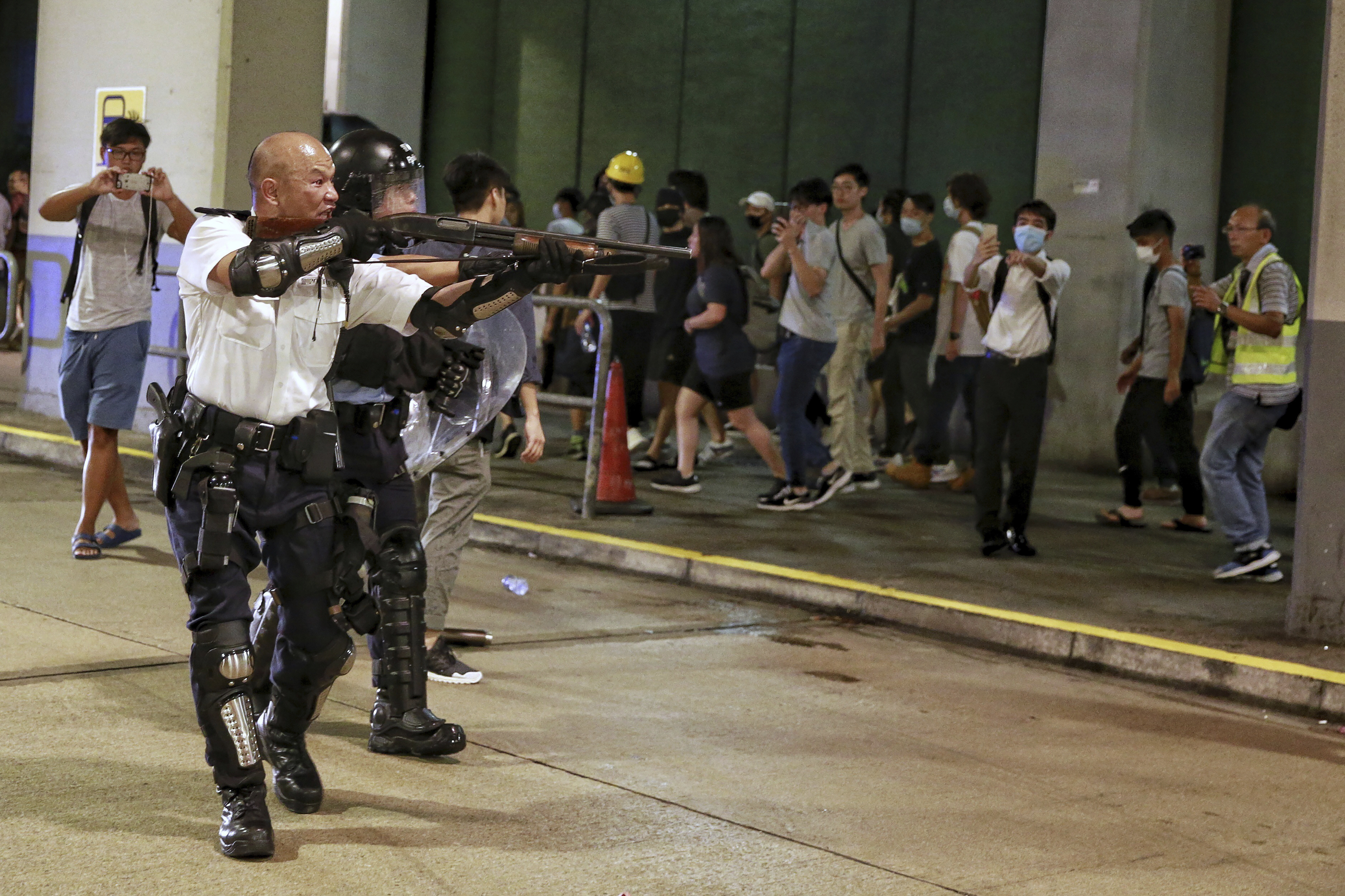 ▲▼香港光頭警長劉澤基7月30日在葵涌警署外舉槍對準示威者。（圖／達志影像／美聯社）