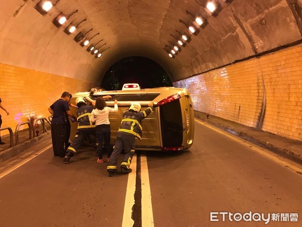▲14日晚間台北市懷恩隧道發生廂型車翻車意外、消防人員到場協助推車排除。（圖／記者張君豪翻攝）