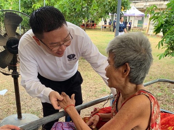 馬來西亞王玟富醫師(左)為老奶奶針灸治療，老奶奶發現自己可以說話，不斷向王玟富醫師道謝。(圖為慈濟基金會提供)