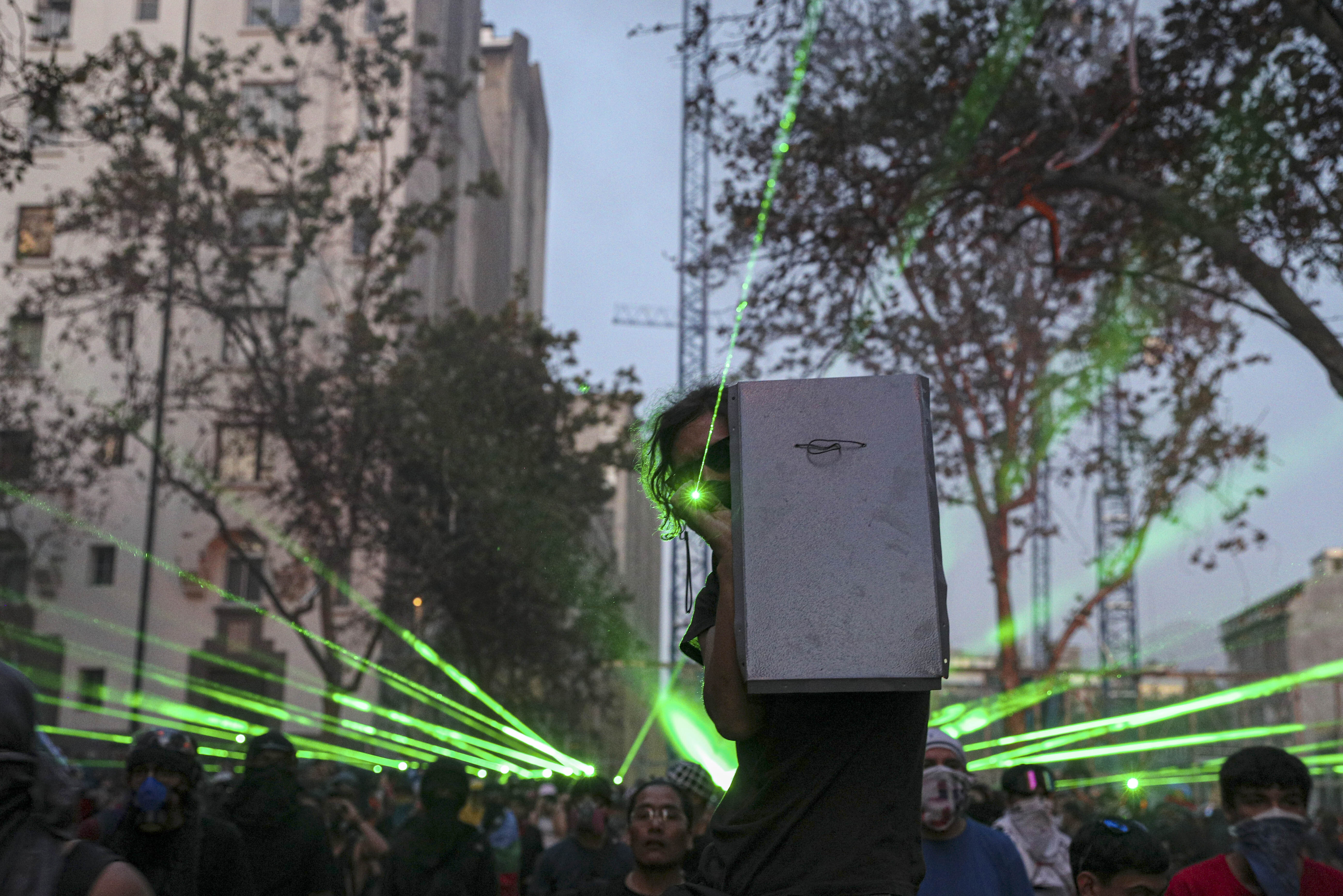 ▲▼智利民眾以雷射筆強光對抗軍警盤旋在上空的無人機。（圖／達志影像／美聯社）