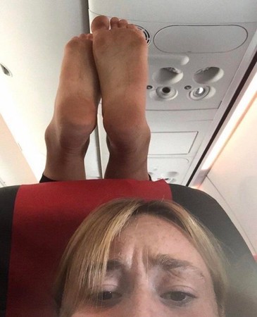 一雙臭腳竟然直接放椅背上！　她崩潰po網：搭飛機最怕遇到...。（圖／翻攝自Reddit）