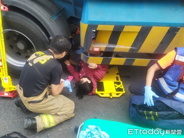 ▲台南市仁德區中山路與中正路三段，發生聯結車與機車車禍事件，女騎士被壓在車底，台南市消防局派員搶救脫困送醫急救。（圖／記者林悅翻攝，下同）