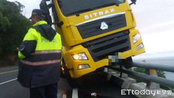 ▲聯結車失控衝入對向車道，撞擊護欄車頭懸空高掛，差一點掉落百米深淵。（圖／台東縣警察局提供，下同）