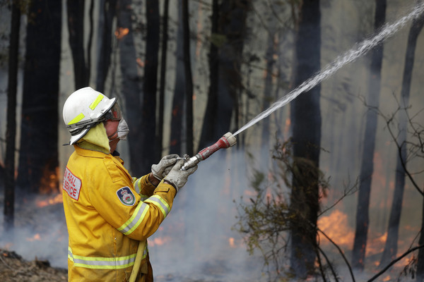 ▲▼澳洲新南威爾斯州一名消防員在火場灑水灌救。（圖／達志影像／美聯社）