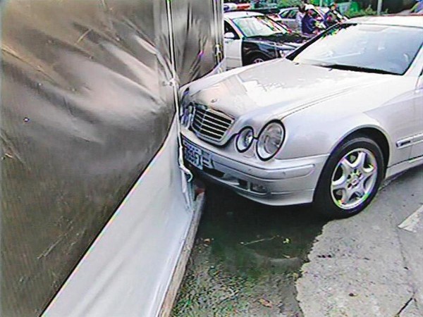 柳東坡遭槍擊後，賓士車一路滑到對街，撞上廣告看板。（東森新聞提供）