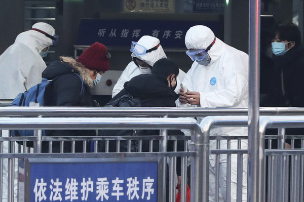 ▲▼ 武漢肺炎,穿著防護衣的保全人員站在北京地鐵站入口處檢查乘客體溫。攝於2020年1月25日。。（圖／達志影像／美聯社）
