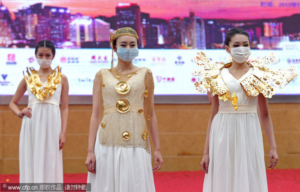 大陸25省市陷霧霾重災，南京，戴著口罩的模特正在展示黃金珠寶飾品。(圖／CFP)