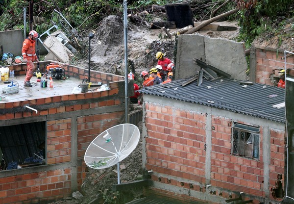 ▲巴西東南部24日、25日暴雨，釀成嚴重洪水，搜救人員在土石掩埋的房舍搜救。（圖／路透）