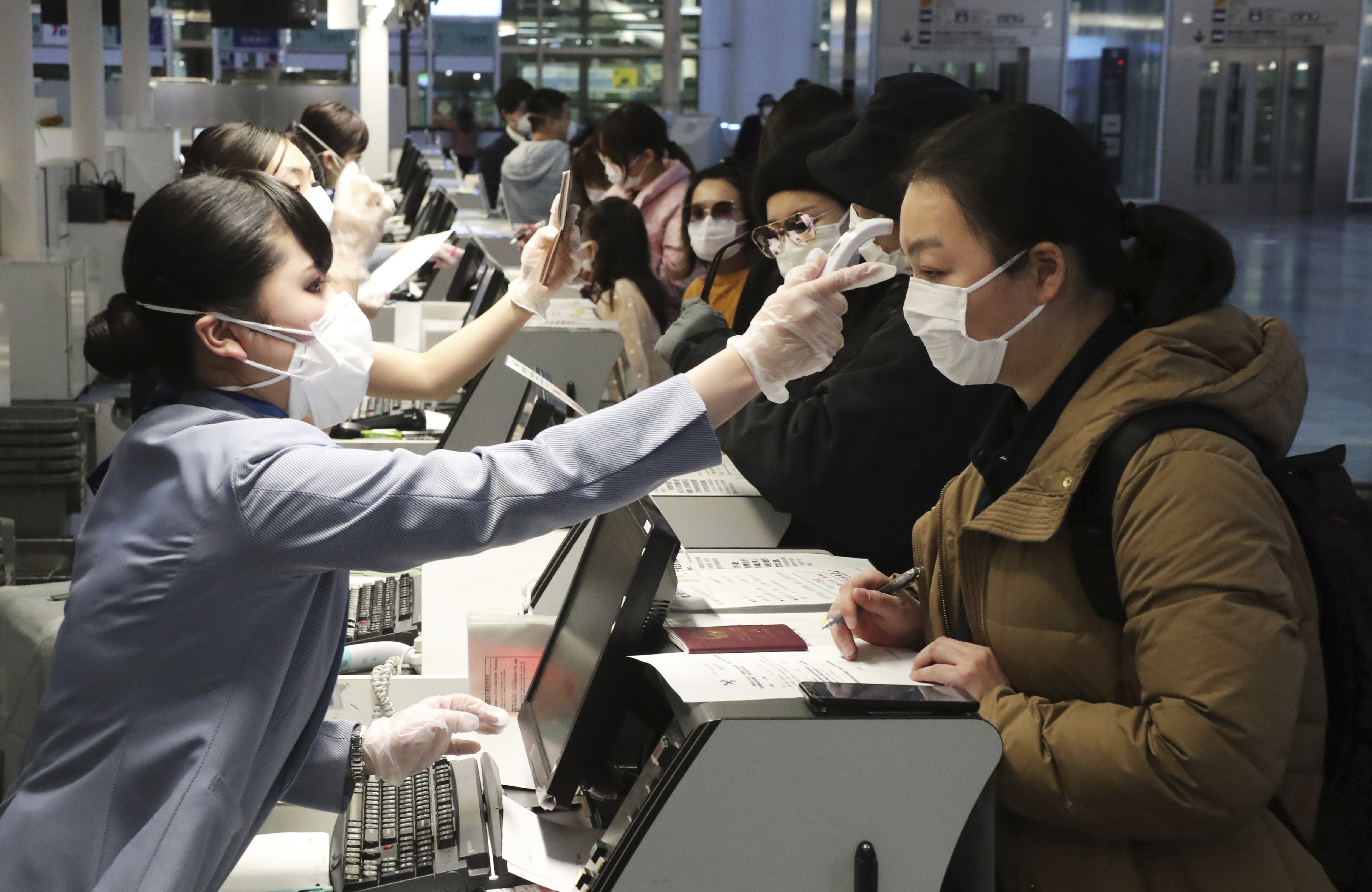 ▲▼ 日本羽田機場地勤測量中國旅客體溫。（圖／達志影像／美聯社）