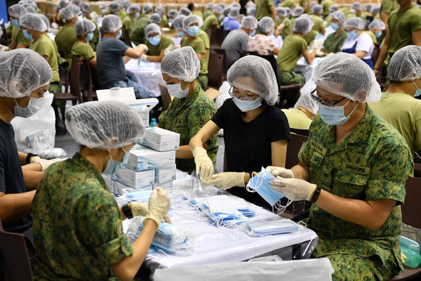 ▲新加坡武裝部隊（SAF）動員士兵協助包裝520萬片外科口罩。（圖／路透）