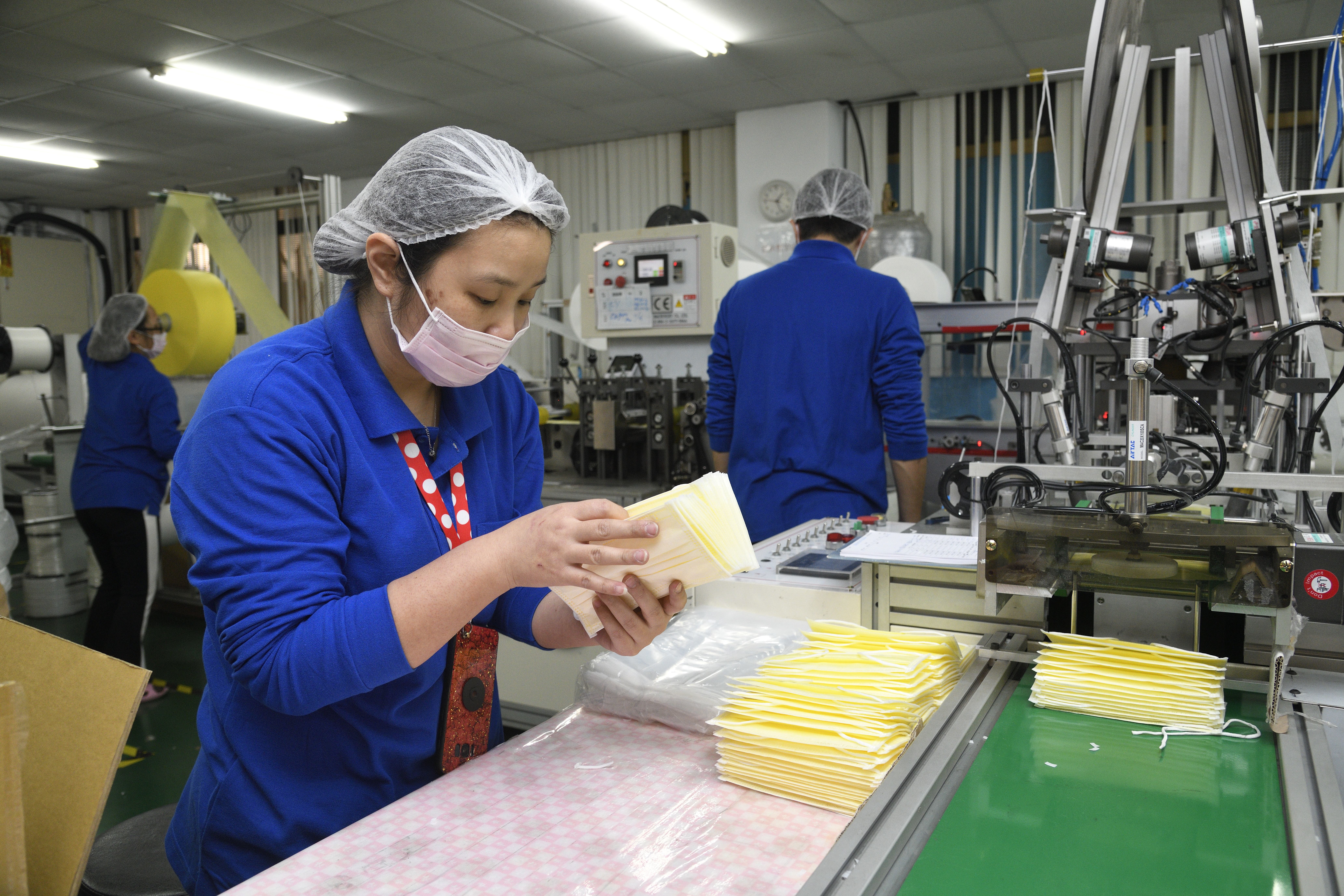 ▲▼威欣利實業有限公司口罩生產線上作業情形。董事長陳怡利表示公司內作業員一天兩班，一班11小時不停趕工生產防疫所需口罩。產能全開一天可產出15萬片以上口罩，並由政府於當天徵用收走。（圖／記者湯興漢攝）