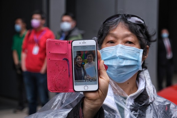 ▲香港民眾排隊領口罩，一名市民當場刪掉和林鄭月娥合照。（圖／香港01授權提供，請勿隨意翻攝，以免侵權）