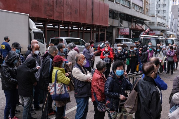 ▲香港民眾排隊領口罩，一名市民當場刪掉和林鄭月娥合照。（圖／香港01授權提供，請勿隨意翻攝，以免侵權）