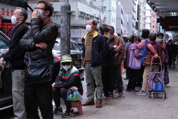 ▲香港民眾排隊領口罩，一名市民當場刪掉和林鄭月娥合照。（圖／香港01授權提供，請勿隨意翻攝，以免侵權）