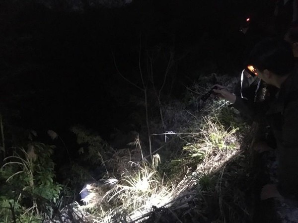 警方在離路邊約10多公尺的山谷內，尋獲包著林女屍體的黑色垃圾袋。（翻攝畫面）