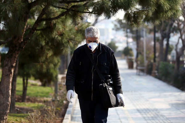 ▲伊朗德黑蘭街頭行人戴上口罩，避免遭肺炎病毒感染。（圖／路透）