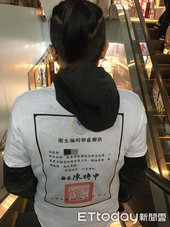 ▲台北萬華一名劉姓藥師收到衛福部的感謝狀，印成T恤穿在身上             。（圖／記者吳奕靖攝）