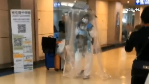 自製防護傘！陸客台灣轉機「塑膠簾子罩全身」：回祖國避難　空服員看傻。（圖／東森新聞）