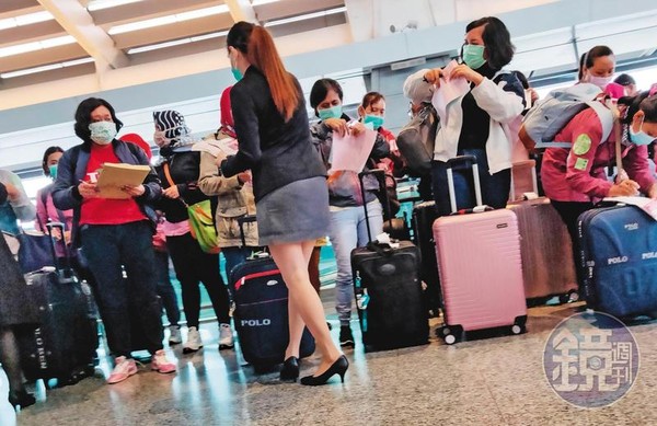 本刊直擊，身穿套裝的預付卡代理商發放預付卡申請單給每個移工填寫。