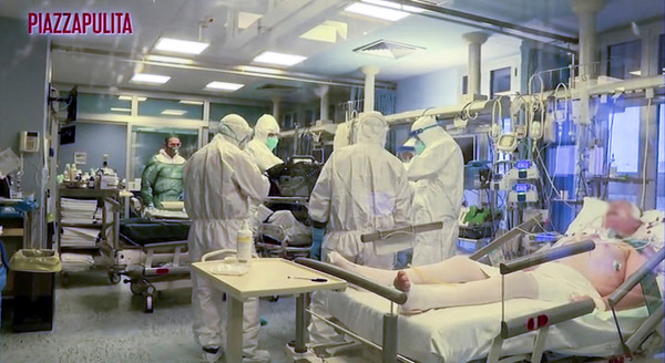 ▲▼義大利醫護人員穿著防護服進入加護病房，治療新冠肺炎患者。（圖／路透）