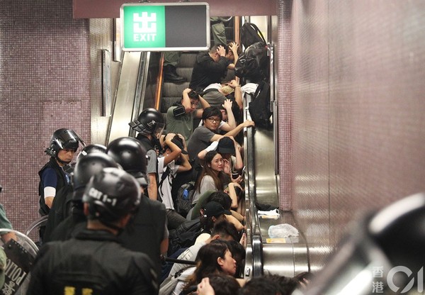 ▲831遊行示威衝突，晚上11點，警方在太子站列車和月台內，拘捕示威者，多名示威者被制服後蹲下等待警方押走。（圖／香港01授權提供，下同）
