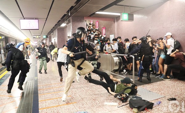 ▲831遊行示威衝突，晚上11點，警方在太子站列車和月台內，拘捕示威者，多名示威者被制服後蹲下等待警方押走。（圖／香港01授權提供，下同）