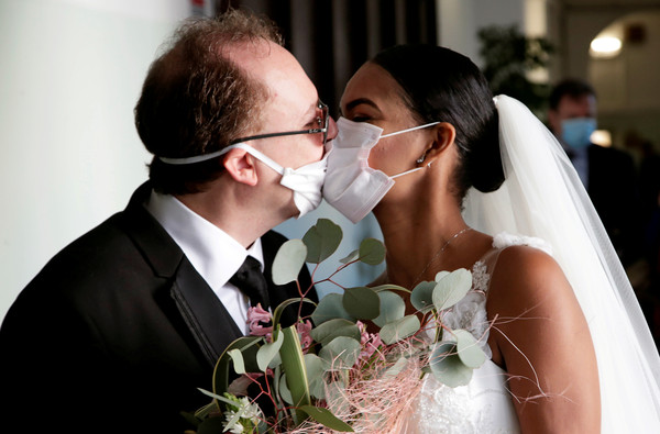 ▲▼義大利一對新人在新冠肺炎疫情爆發中完婚，兩人戴著口罩親吻。（圖／路透）