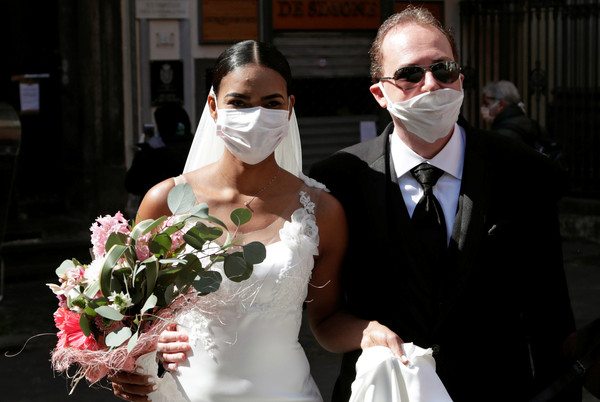 ▲▼義大利一對新人在新冠肺炎疫情爆發中完婚，兩人戴著口罩親吻。（圖／路透）