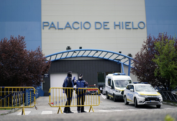 ▲數名員警周一駐守在馬德里馬德里冰宮外面。該座冰宮已被政府徵用作停屍間。(圖／路透)