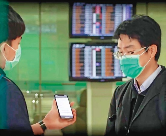 電子圍籬系統的「旅客入境健康聲明暨居家檢疫電子化系統」，台灣旅客持手機掃QR Code就可線上填健康資訊，並在入境時秀出簡訊憑證快速通關。（翻攝中央流行疫情指揮中心影片）