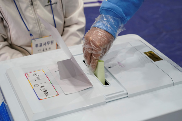 ▲▼在15日的南韓國會大選中，選民必須遵守戴手套投票等相關防疫規定。（圖／路透）