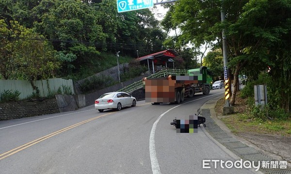 ▲桃園市復興區17日清晨6時許，機車欲超車砂石車卻翻覆遭連續輾壓，警方趕抵後，機車被移至路旁等待調查肇事原因。（圖／記者沈繼昌翻攝）