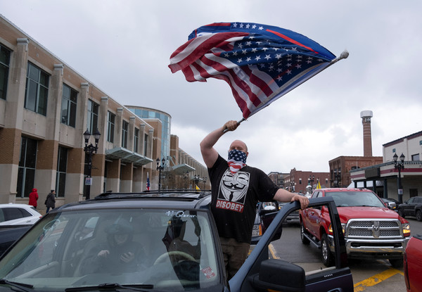 ▲▼美國密西根州一名男子揮舞國旗，抗議當局延長「居家令」。（圖／路透）