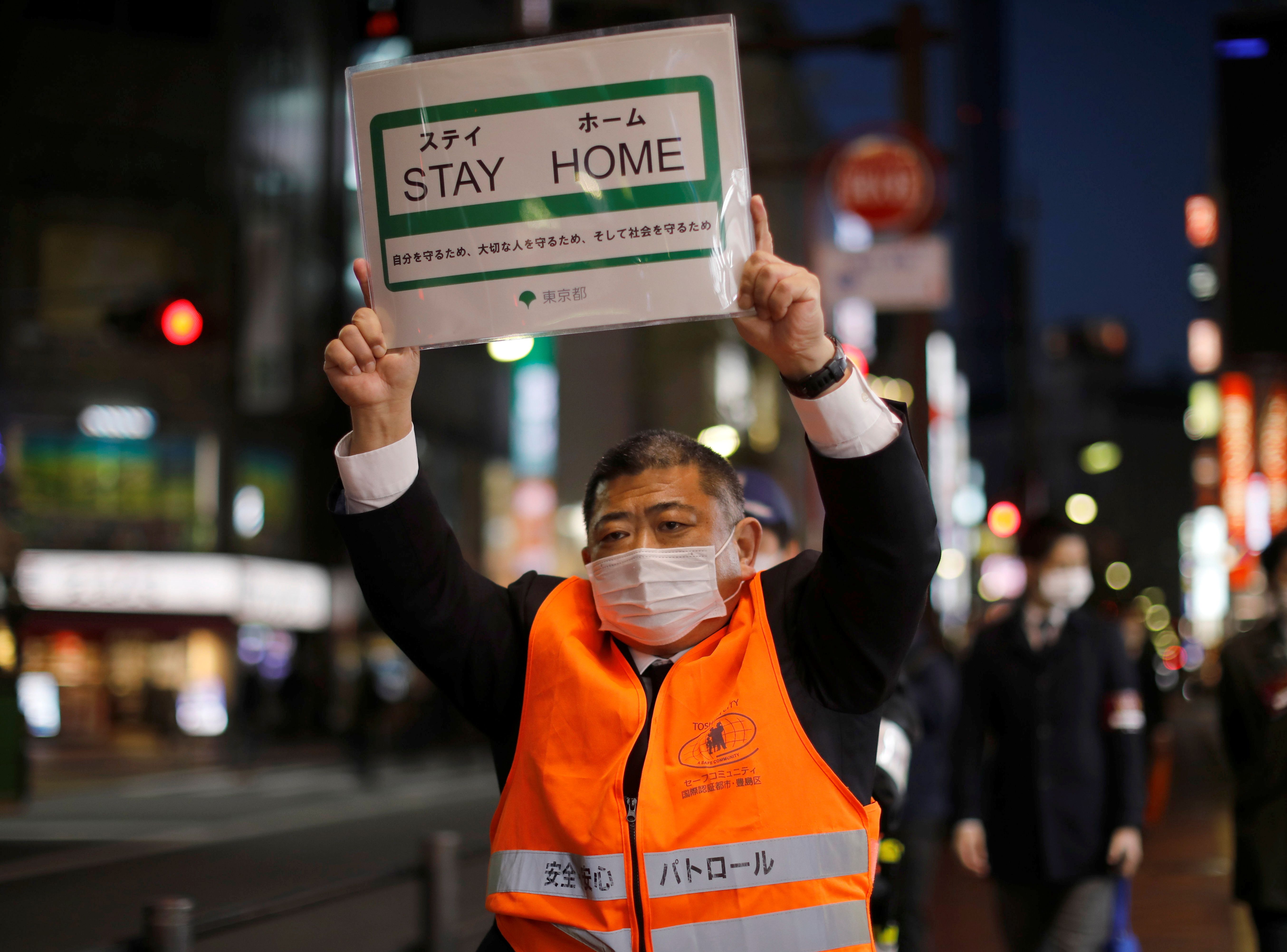 ▲▼東京都廳工作人員戴著口罩上街，呼籲民眾待在家中。（圖／路透）