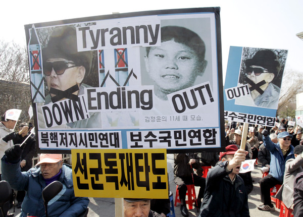▲▼南韓民眾2009年抗議北韓的軍事政策，告示牌可見金正日與金正恩小時候。（圖／達志影像／美聯社）