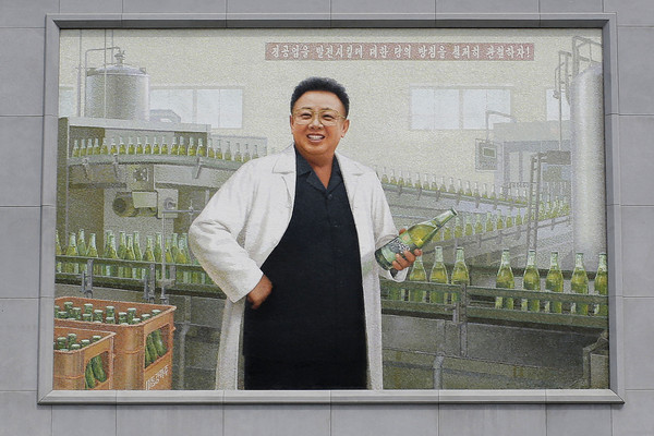 ▲北韓前領導人金正日在壁畫中身穿白色實驗袍，舉起北韓出產的「大同江啤酒」（Taedonggang Brewery）。（圖／達志影像／美聯社）