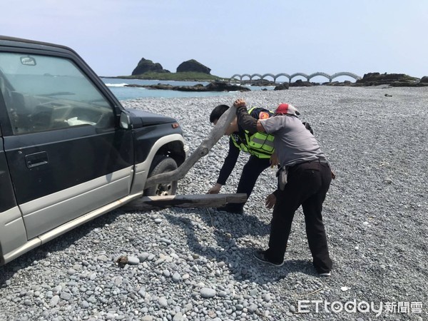 ▲▼ 釣友地形不熟車陷三仙台海灘，員警豔陽下推車解圍。（圖／台東縣警局提供，下同）